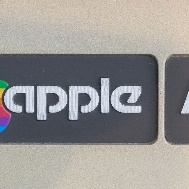Close-up of retro Apple IIe computer logo featuring rainbow apple symbol, showcasing vintage technology design.