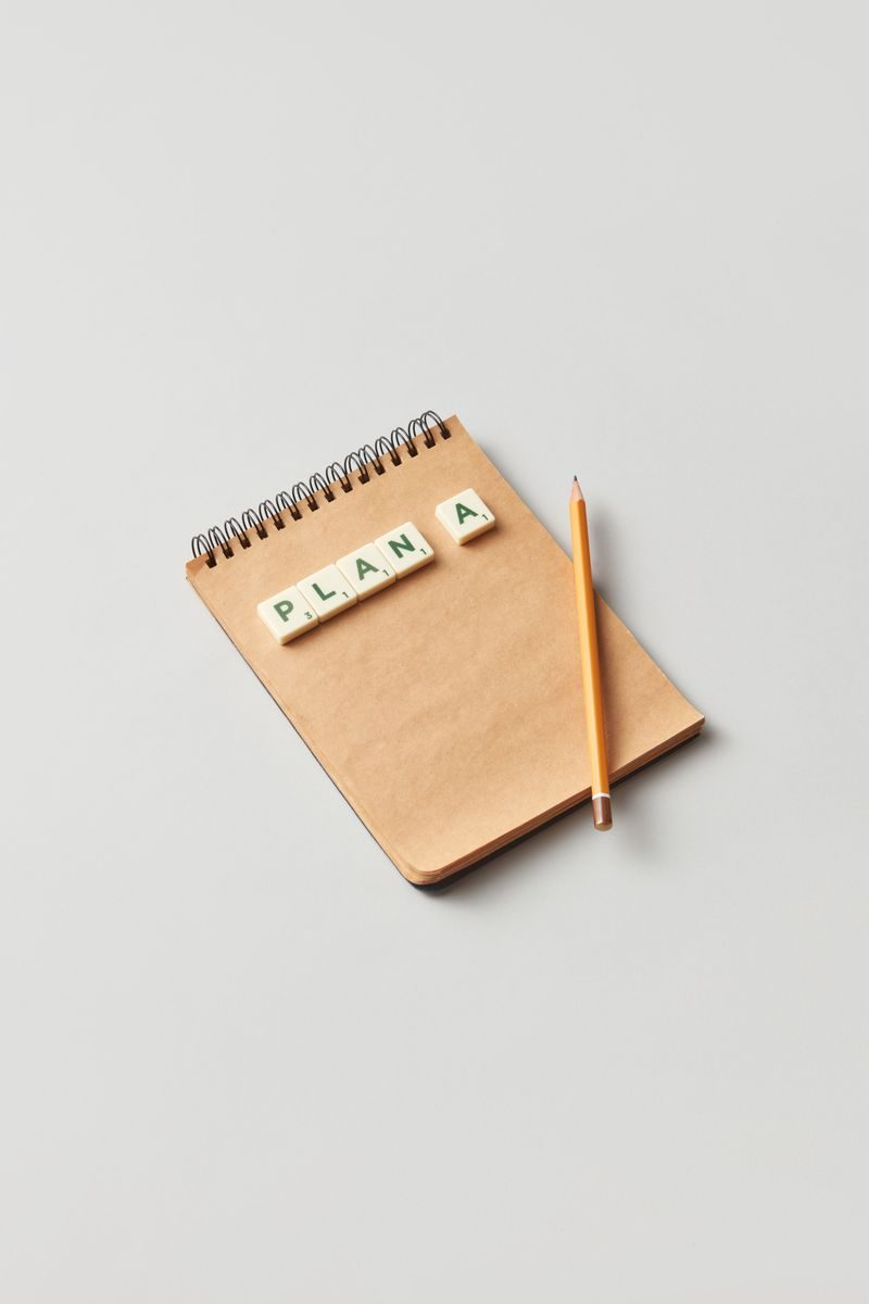 Minimalistic image of a notepad with letter tiles and pencil on a neutral background.