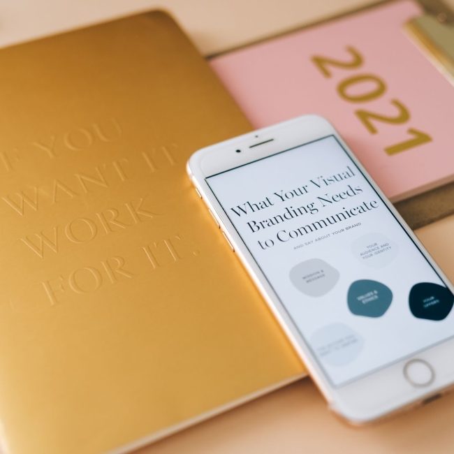 A smartphone and notebook on a desk for business planning and branding strategy.